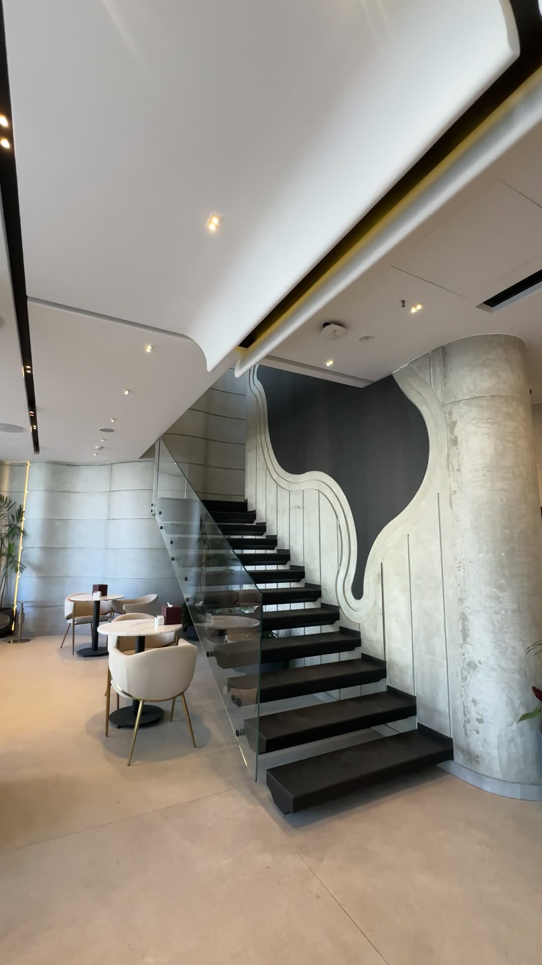 Mocha floating staircase with chocolate-pour wall art